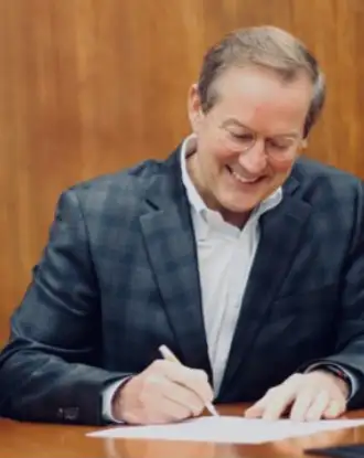 Halsey Cool, CEO of Milliken, signing a document