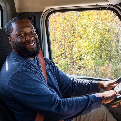 Picture of man smiling behind the wheel of a semi truck